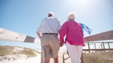Yaşlı çift birlikte sahilde yürüyüş