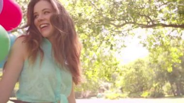 Bir sürü balon bir parkta tutan kız