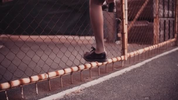 Übertretendes Afro-Mädchen klettert über Zaun — Stockvideo