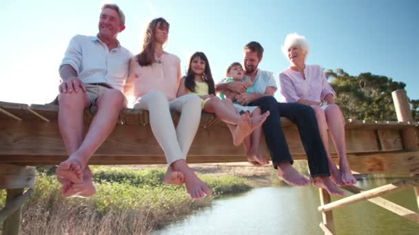 Three generation family relaxing on a jetty Royalty Free Stock Footage