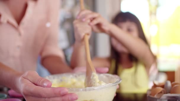 Little girl stirring cake ingredients with mom — Stock Video