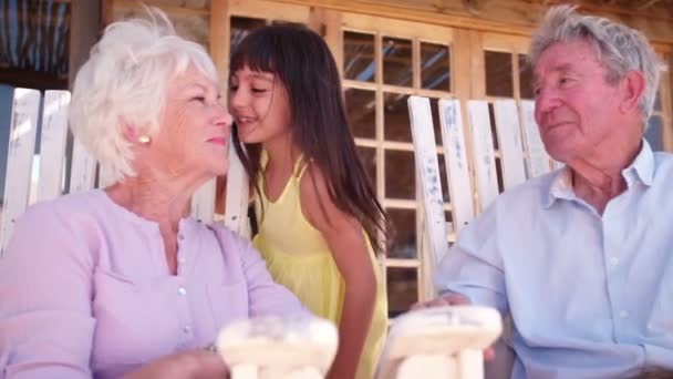 Niña dándole un beso a su abuela — Vídeo de stock