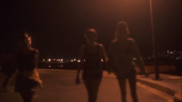 Chicas caminando bajo una luz de calle — Vídeo de stock