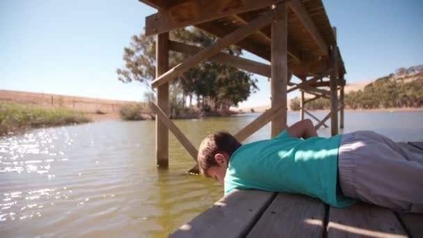 Garçon couché sur une jetée — Video