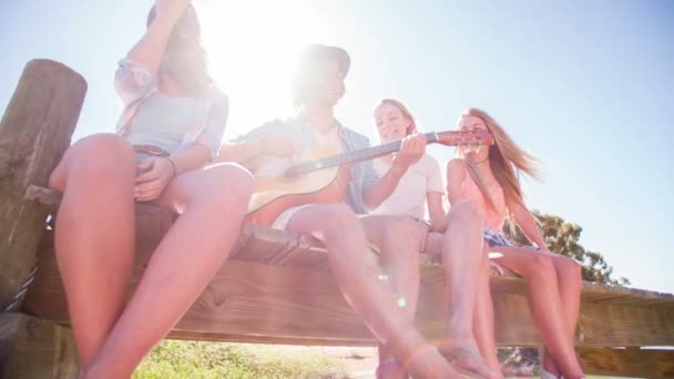 Killen som spelar gitarr för tonåring flickor — Stockvideo