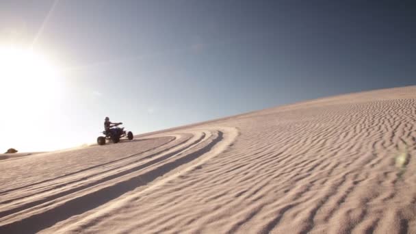 Quad racer rijden op een zand-duin — Stockvideo