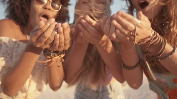 Chicas soplando confeti en la playa — Vídeos de Stock