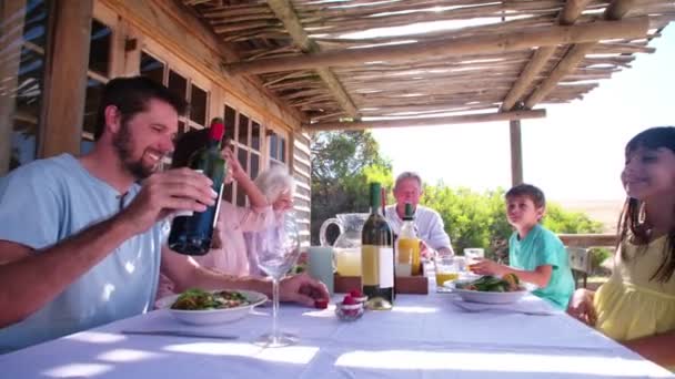 Tre generation familj njuta av en måltid — Stockvideo