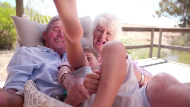 Far-och morföräldrar kittlande deras sonson — Stockvideo