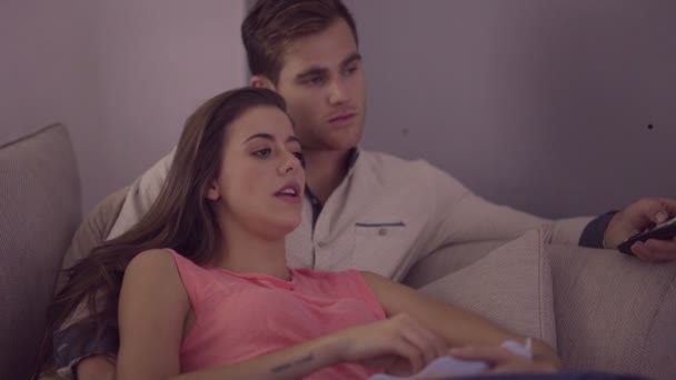 Couple sur canapé regarder la télévision — Video
