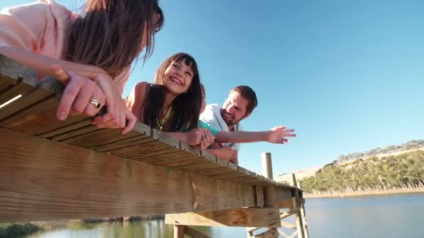 Familjen liggande tillsammans på en brygga — Stockvideo