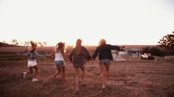 Amigos adolescentes corriendo cuesta abajo al atardecer — Vídeo de stock