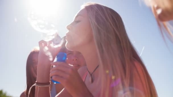 Chica soplando burbujas con amigos — Vídeos de Stock