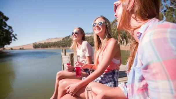Adolescente chica amigos sentado en un embarcadero — Vídeo de stock