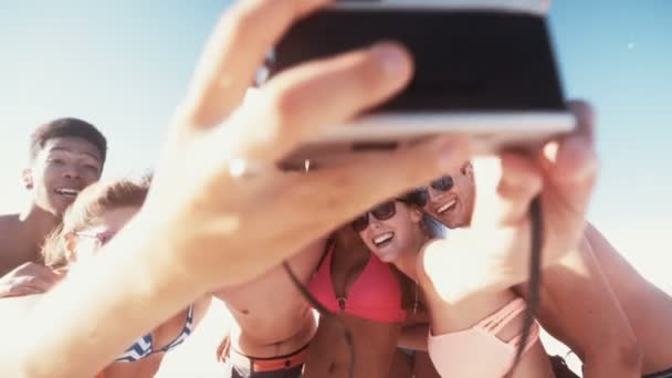 Amigos tirando uma selfie de grupo em uma praia — Vídeo de Stock