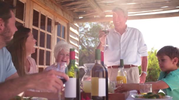 Großvater prostet seiner Familie beim Essen zu — Stockvideo