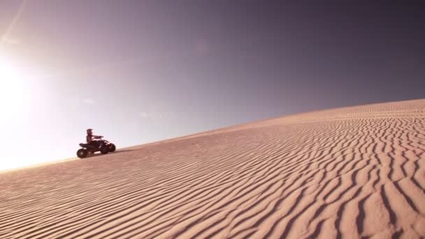 Quad motociclista viajando até duna de areia — Vídeo de Stock