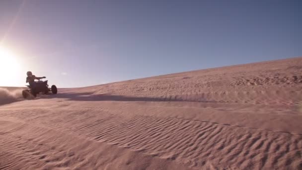 Quad racer rijden op een zand-duin — Stockvideo