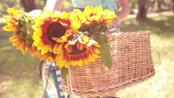 Zonnebloemen in de fiets mand met meisje — Stockvideo