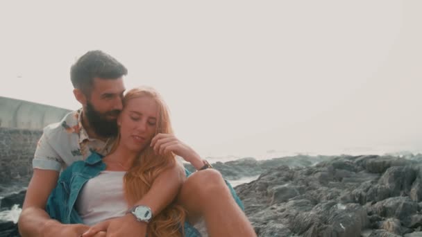 Couple sitting on rocks at seaside — Stock Video