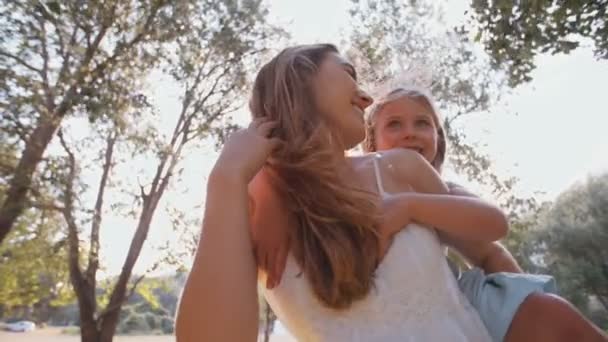 Дочь радуется катанию на спине на матери — стоковое видео