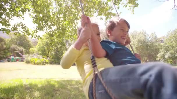 Девочка и мальчик пытаются качаться высоко — стоковое видео