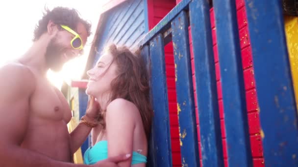 Couple kissing in front of beach huts — Stock Video