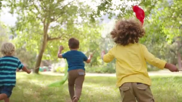 Crianças correndo no parque com bandeiras coloridas — Vídeo de Stock