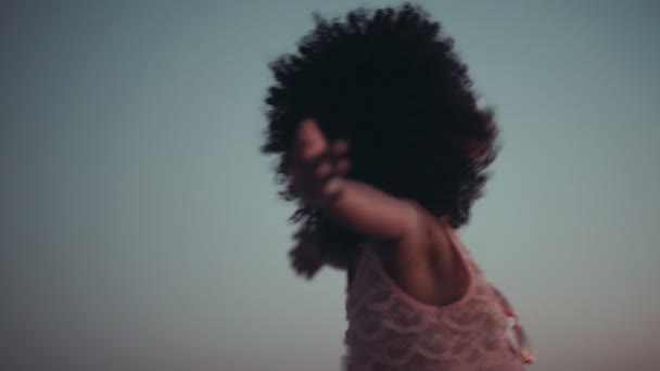 Menina afro desfrutando do pôr do sol na praia — Vídeo de Stock