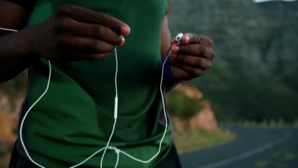 Corredor afroamericano poniendo sus auriculares — Vídeos de Stock