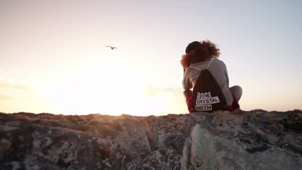 Afro meisje, zittend op een strand bij zonsondergang — Stockvideo