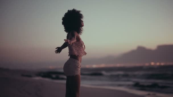 Menina afro desfrutando do pôr do sol na praia — Vídeo de Stock