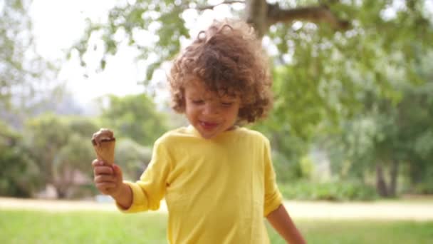 Мальчик с мороженым в парке — стоковое видео