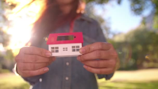 Mujer presentando casa de juguete con células solares — Vídeos de Stock