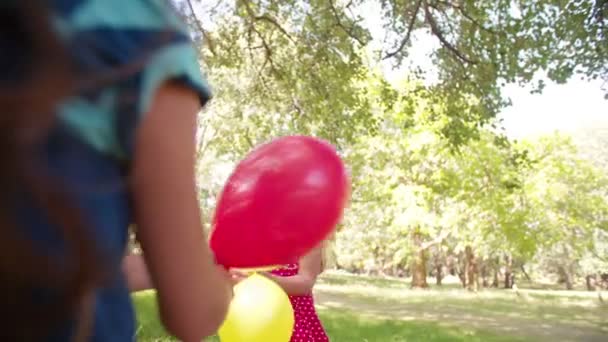 Meisjes met plezier met heldere ballonnen — Stockvideo