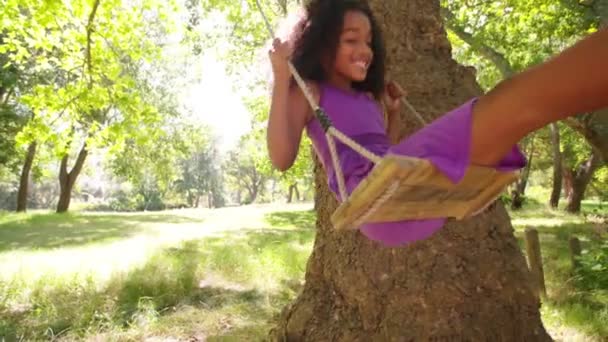 Afro-Mädchen schaukelt verspielt im Park — Stockvideo