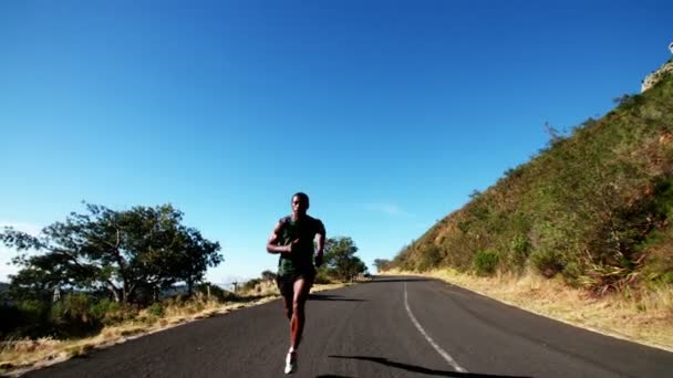 Atleta corriendo por la carretera al aire libre — Vídeo de stock