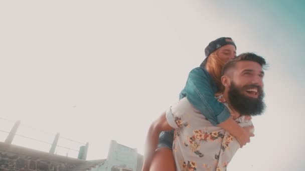 Hipster guy piggybacking his girlfriend — Stock Video