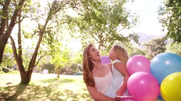 Madre e hija en parque con globos — Vídeos de Stock