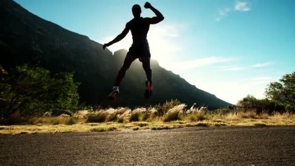 Спортсмен с триумфом взлетает в воздух — стоковое видео