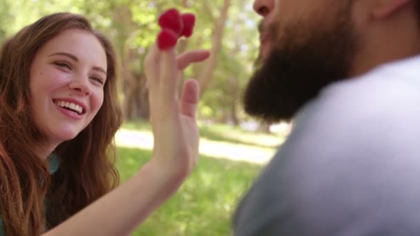 Chica alimentando a su novio frambuesas — Vídeos de Stock