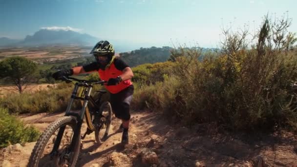 Mountainbiker duwen zijn fiets — Stockvideo