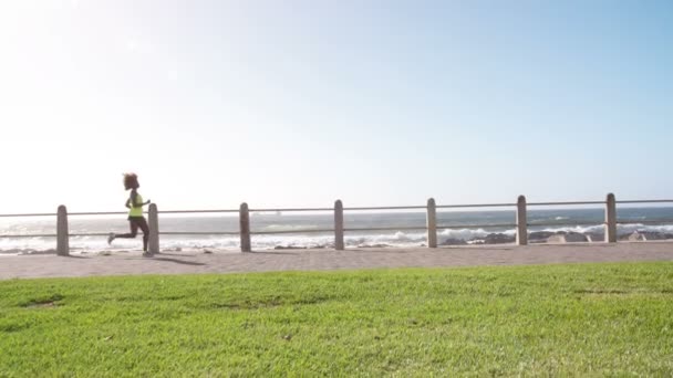 Female athlete jogging along the beach — Stock Video