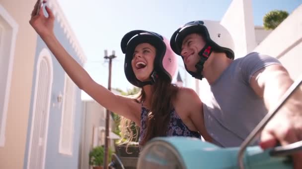 Pareja en un scooter tomando una selfie — Vídeo de stock