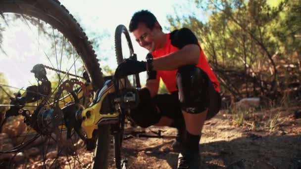 Mountain biker reparing his broken bike — Stock Video