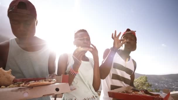 Freunde lachen zusammen, während sie Pizza teilen — Stockvideo