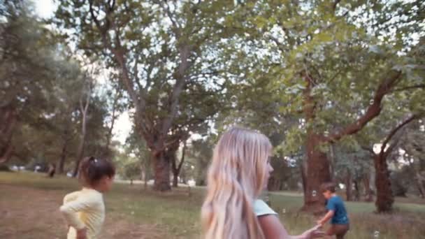 Děti běží a honí bubliny v parku