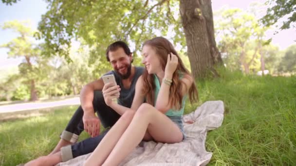 Casal sorrindo para algo em um telefone — Vídeo de Stock