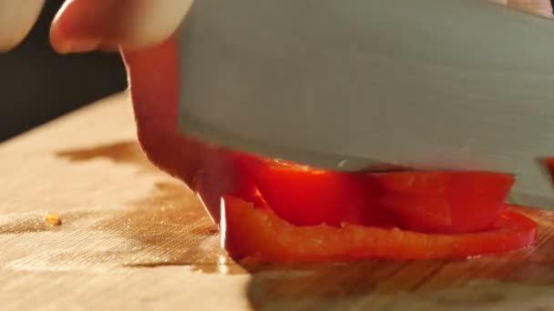 Person schneidet rote Paprika — Stockvideo