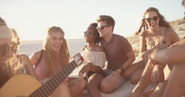 Bir gitar ile bir gün batımı beachparty arkadaşlar